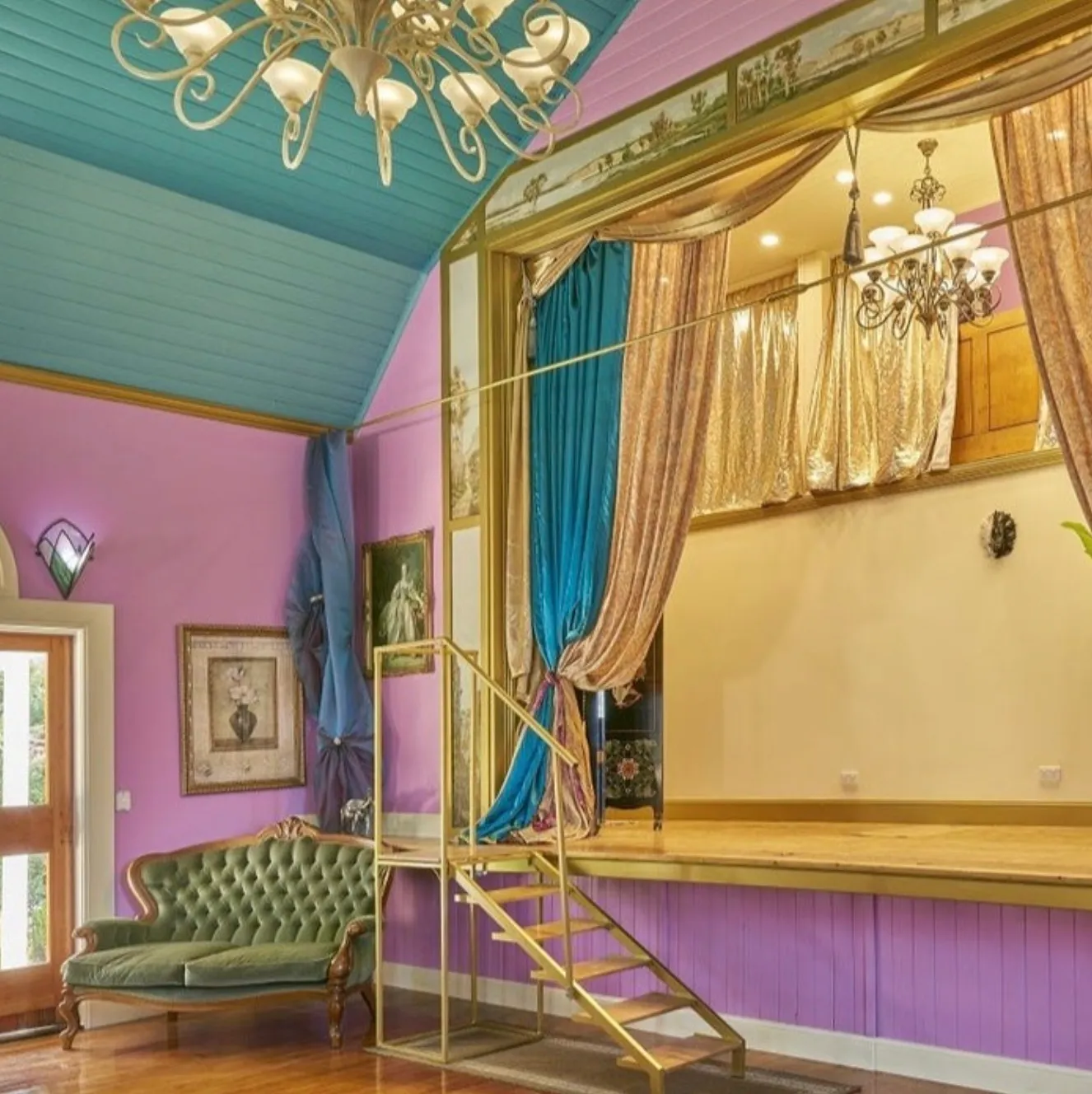 Inside the Church of the Arts: lilac walls, a teal ceiling, a chandelier, a gilded stage with velvet curtains